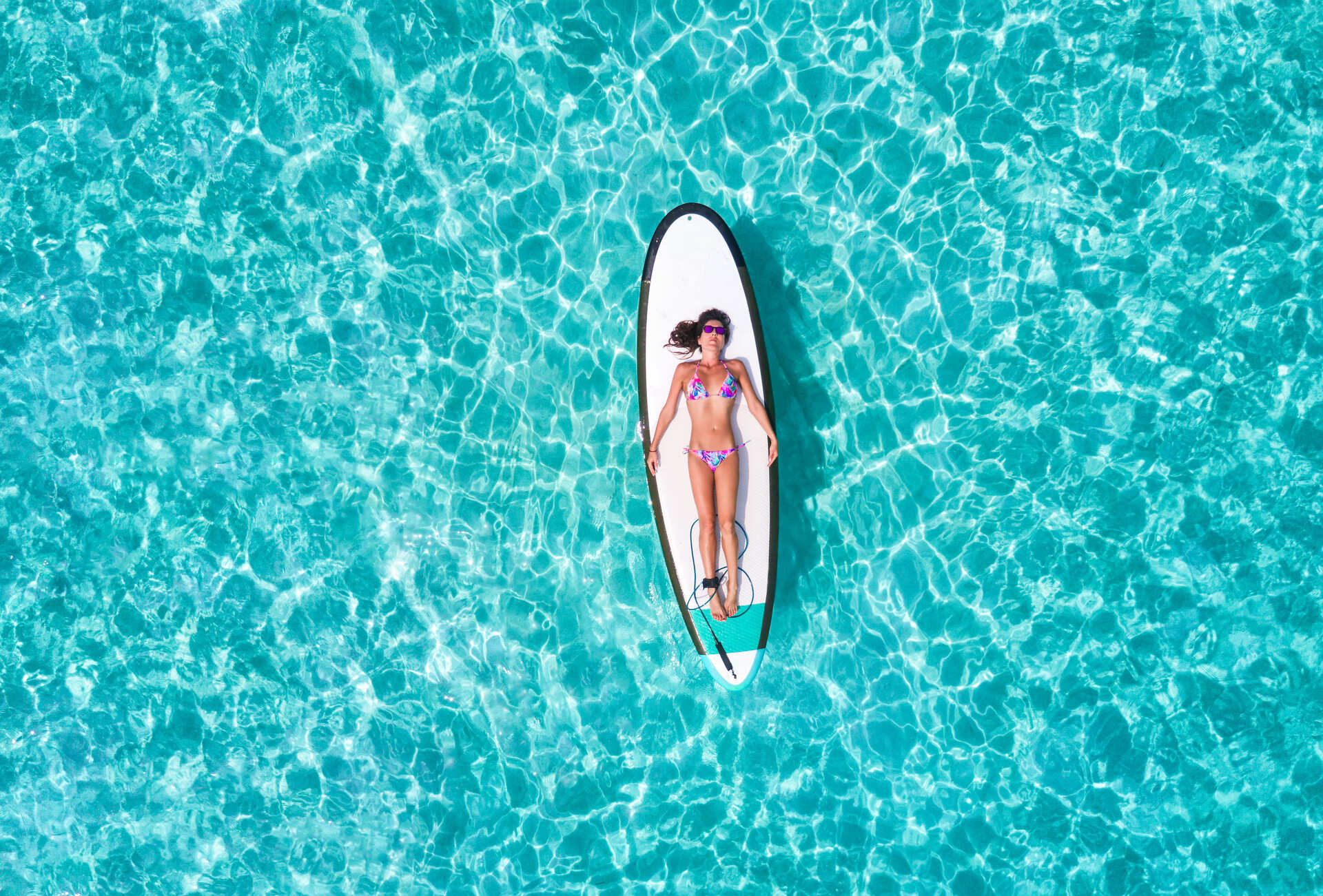 aerial-view-woman-bikini-lying-surfboard-sea.jpg__PID:90d4fd58-7c20-487a-a935-9c5dad40f466